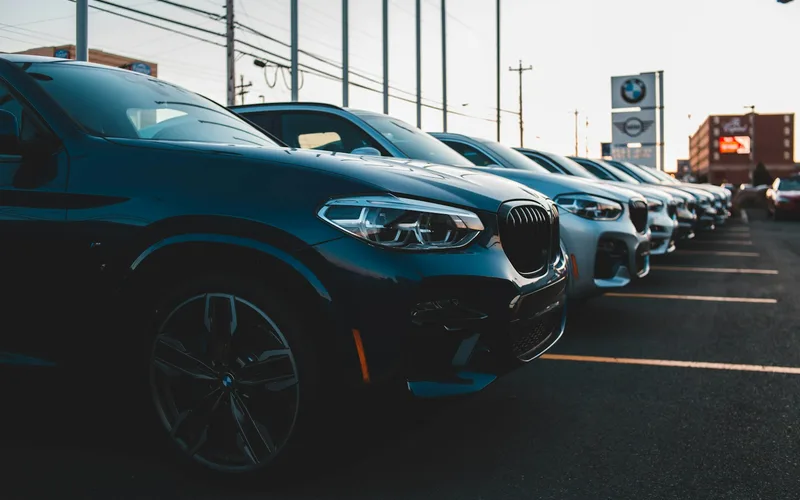 Rows of cars parked outside a dealership showroom